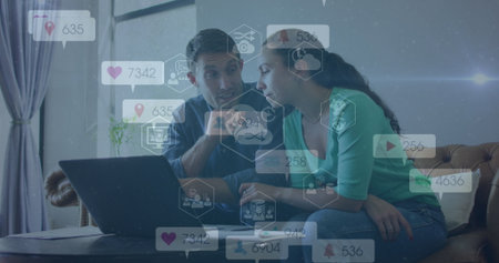 Couple reviewing metrics on laptop in living room, with social media analytics icon overlays....