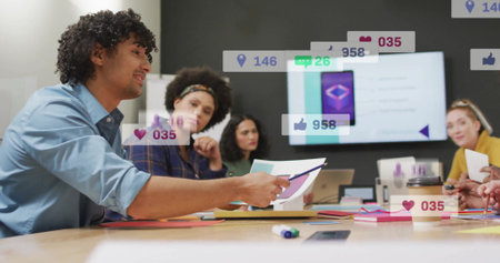 Discussing office-attired team reviewing documents on table in meeting room with social media icons. Collaboration, teamwork, corporate, professional, brainstorming, communication, modernの写真素材