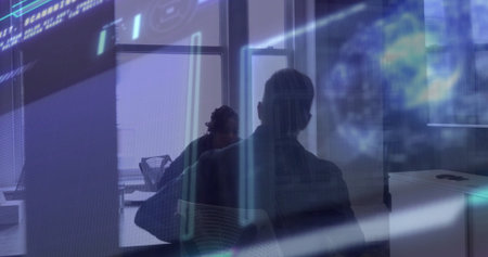 Two office professionals analyzing digital UI in glass-walled conference space, with laptop on desk....