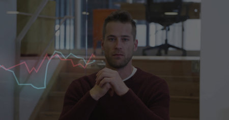 Sitting man folding hands on desk in office with glass partition, wooden staircase and line charts....