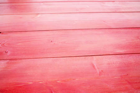 Flat design showing red painted wooden planks covering width, highlighting grain textures and seams. Rustic, vibrant, textured, craftsmanship, natural, colorful, architecturalの写真素材