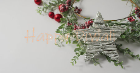 Displaying flat-lay wreath and frosted star ornament on tabletop, with glittery Happy Diwali text. Festive, holiday, seasonal, decor, celebration, elegant, minimalistの写真素材