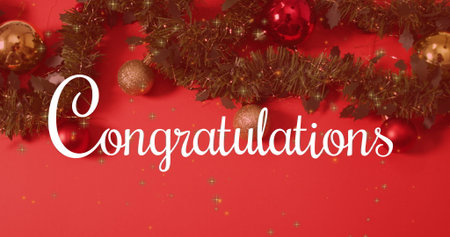 Displaying white cursive 'Congratulations' text on red wall, with green tinsel garland and baubles. Festive, celebratory, holiday, seasonal, decorative, glamorous, cheerfulの写真素材