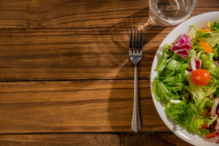 Overhead view of healthy bowl of salad on wooden tableの写真素材