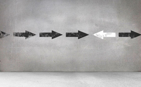 Arrow signs on gray wallの写真素材