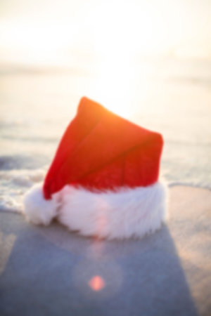 Santa claus hat on beach against sunny skyの写真素材