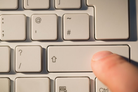 Finger pressing shift key on keyboard