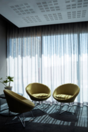 Empty chairs on floor against curtains hanging on windowの写真素材