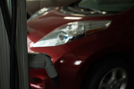 Close-up of charging plug hanging at charging station
