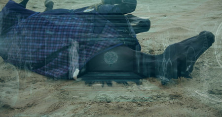 Lying face-down adult wearing plaid coat with tactical boots on desert shore with tech HUD overlays....