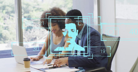 Colleagues analyzing documents and holographic overlays in office meeting room, with laptop....