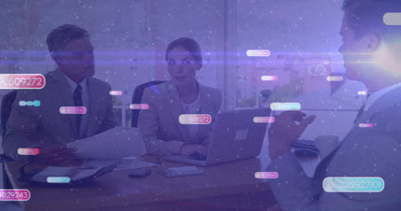 Reviewing team in suits discussing data with digital overlays on laptop and reports in meeting room. Corporate, collaboration, analytics, modern, professional, teamwork, technologyの写真素材