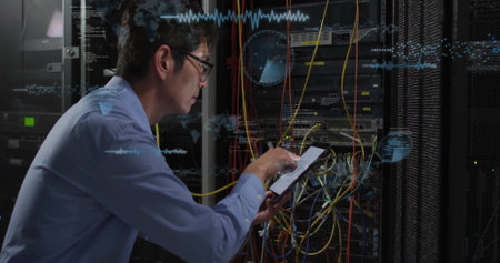 Examining wiring, IT technician using tablet in data center, network racks, cables, copy space....