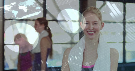 Smiling woman in sportswear holding white towel around neck in fitness studio, with digital overlay....