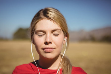 Beautiful woman listening to music on headphones on a sunny day