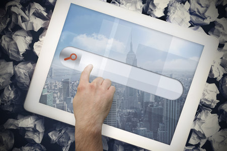 Hands touching search bar on tablet screen on crumpled up paper