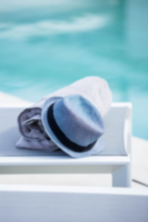 Towel and hat on table at poolsideの写真素材