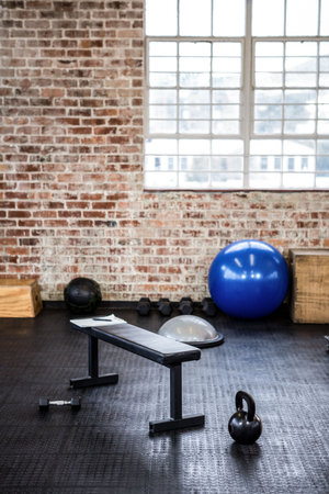 Gym equipment in fitness studio against window