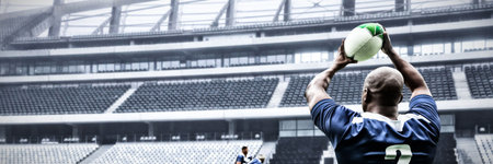 Rear view of rugby player throwing the ball in sports stadiumの写真素材