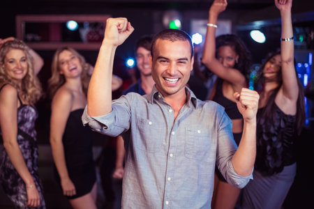Portrait of happy man dancing at party in discoの写真素材