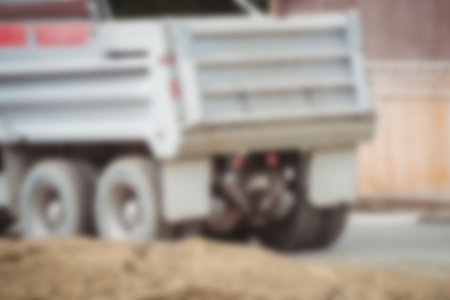 Defocused image of dumper truck on road by construction siteの写真素材