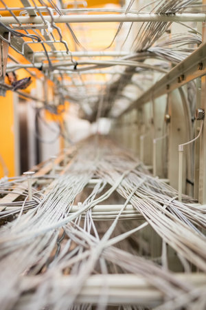 White and gray network cables are stretching along metal trays in 3D render server room. Data...