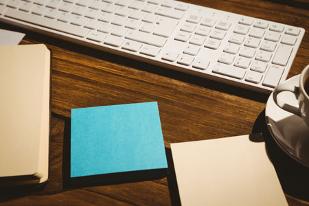 High angle view of keyboard and coffee cup on table with papers