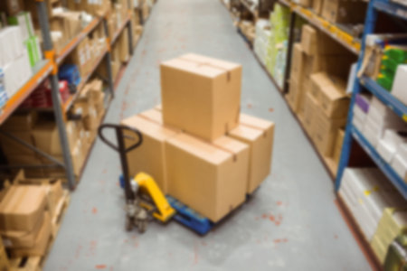 Hand truck carrying cardboard boxes in storage room