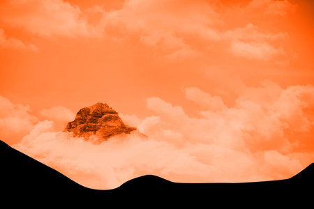 Solitary mountain peak is emerging above thick cloud layer in flat design, with ridge silhouettes....