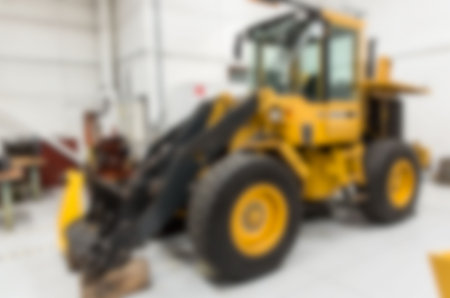 Defocused image of earth mover parked in factory