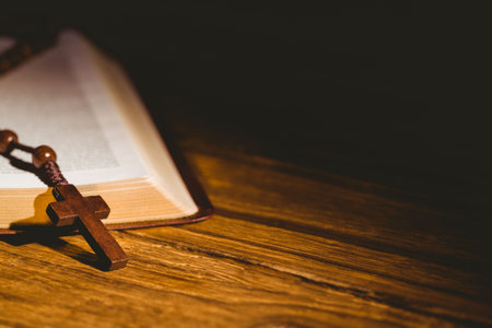 Bible kept on hardwood floor with rosary beadsの写真素材