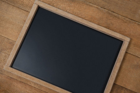 High angle view of tilt chalkboard on wooden table