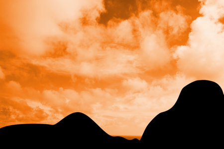 Silhouetted rolling hills are creating minimalist flat design scene with warm orange sky and clouds. Finity, landscape, natural, serenity, tranquil, dusk, horizonの写真素材