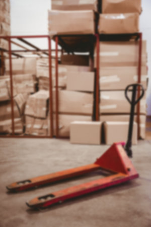 Pallet jack against cardboard boxes in distribution warehouse
