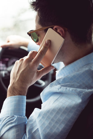 Man driver using smart phone in car