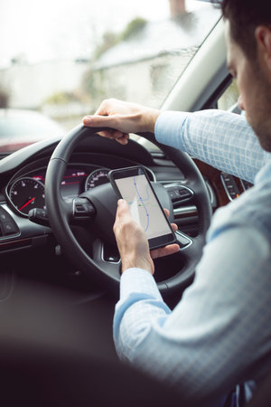 Man driver using smart phone in car