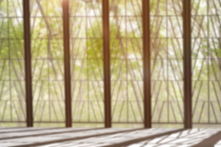 Glass window with metal bars against treesの写真素材