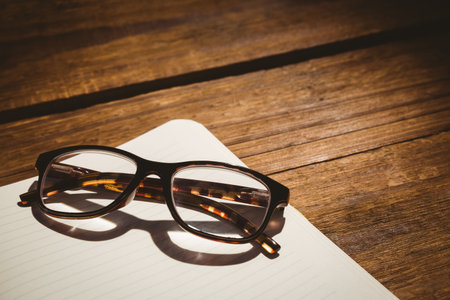 Close-up of black eyeglasses on tableの写真素材