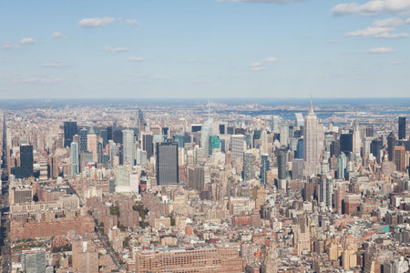 Glass skyscrapers with spire are towering over brick grid streets and water horizon in flat design....
