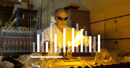 Goggled glassblower working at workbench shaping glass tubing by torch flame, digital chart overlay....