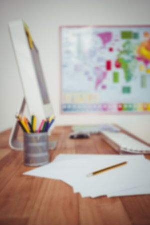 Papers by desktop pc on desk in officeの写真素材