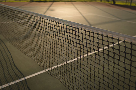 Tennis net is featuring white net band and sunlit painted hardcourt lines in flat design art. Sports, recreation, athletic, outdoor, vibrant, energetic, realismの写真素材