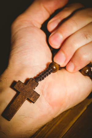 Close-up of hand holding rosary beadsの写真素材