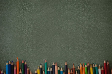 Overhead view of colored pencils on gray table borderの写真素材