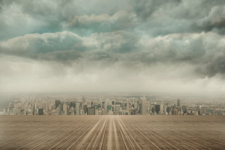 wooden deck platform is guiding gaze toward city skyline under looming storm clouds. Urban, skyline, moody, atmospheric, architecture, panoramic, skylineviewの写真素材