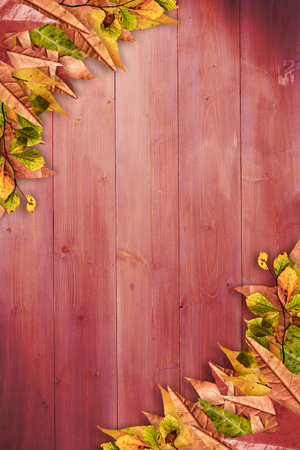 Red-painted wooden plank backdrop is being shown with autumn leaf clusters in flat design. Rustic, seasonal, nature, autumnal, textured, vibrant, artistryの写真素材