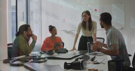 Discussing drone assembly, team leaning over table in office with frame and VR headset. Innovation,...