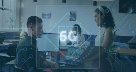 Three professionals analyzing digital 6G overlay in office, holding laptop and pointing at monitor. Collaboration, innovation, technology, modern, teamwork, digital, office environmentの写真素材