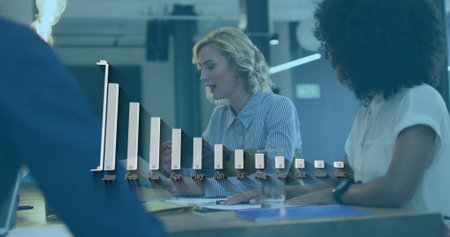 Reviewing monthly data among coworkers in office meeting, using 3D bar chart overlay and documents....