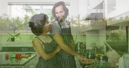 Embracing cooking couple stirring frying pan on stovetop at kitchen island, with tomatoes and herbs. Domestic, culinary, vibrant, romantic, cozy, collaboration, lifestyleの写真素材